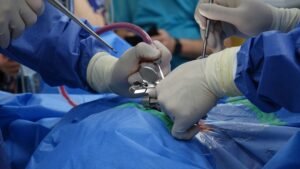 Surgeons in sterile gloves perform a spinal operation in a modern operating room, focusing on precision and care.